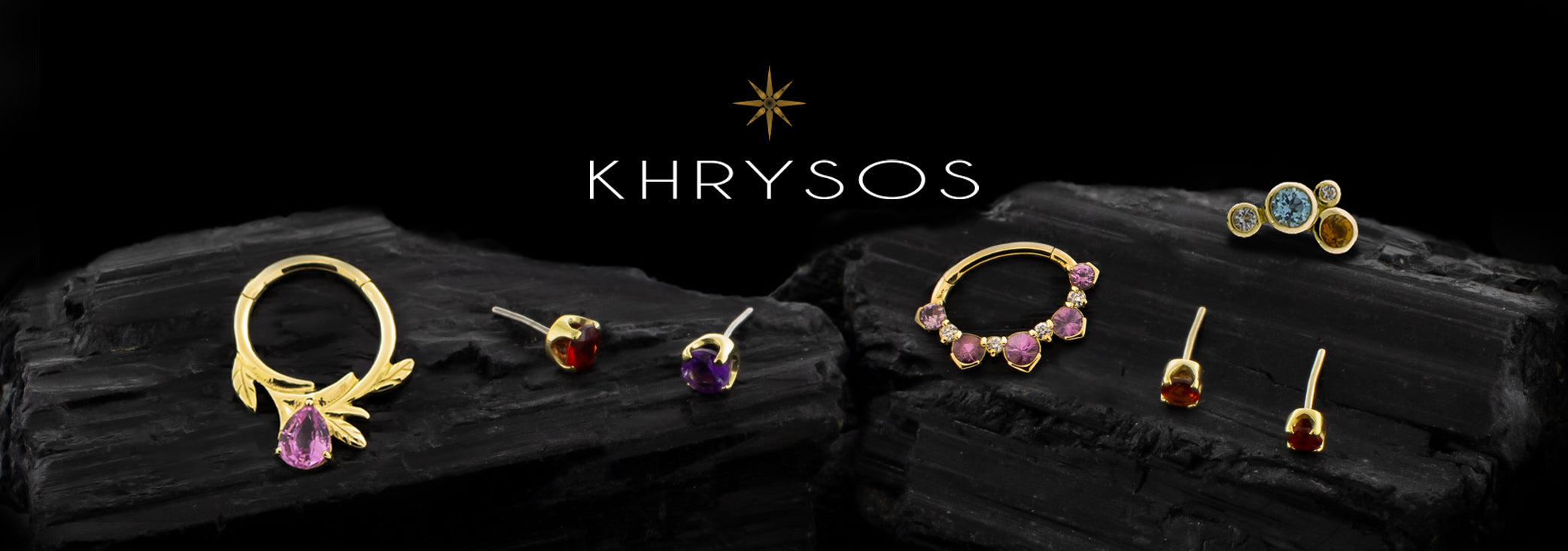 Solid 18kt yellow gold body jewelry with colored genuine gemstone on black rocks. 
